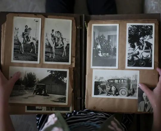 Mãos folheando um álbum de fotos antigas